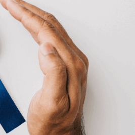 Two hands gently holding a blue ribbon, symbolizing support and awareness for Men's Health Month, with a focus on mental health.