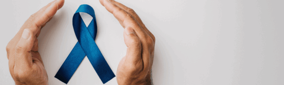 Two hands gently holding a blue ribbon, symbolizing support and awareness for Men's Health Month, with a focus on mental health.