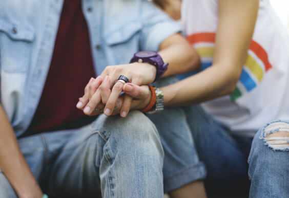 Couple holds hands.