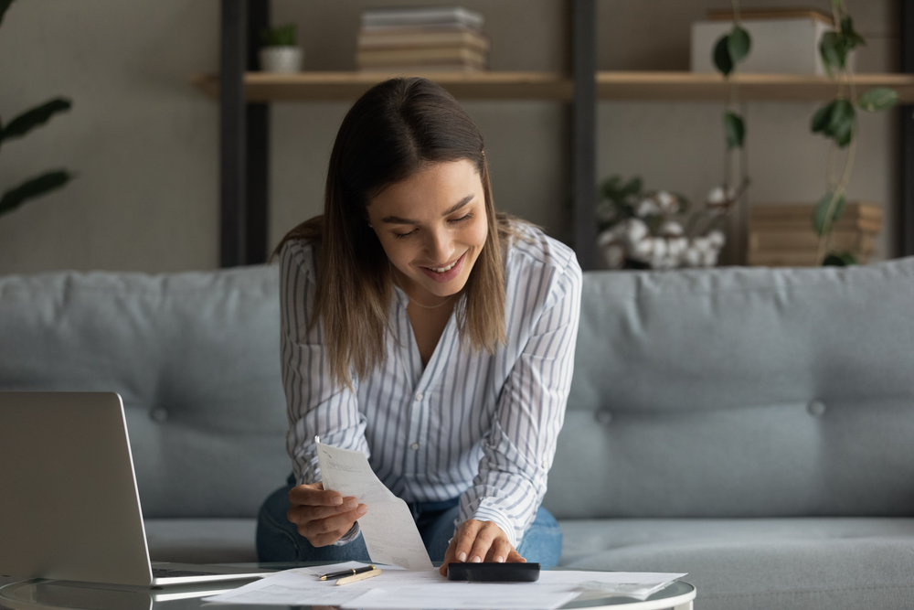 woman sitting on the couch working on personal finance and financial anxiety