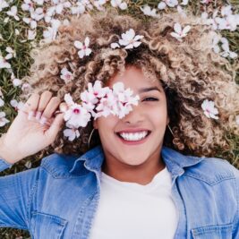 Woman laying down in field of flowers, practicing mindfulness for mental health