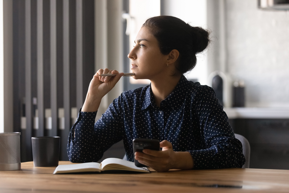 Young woman writes down mental health goals